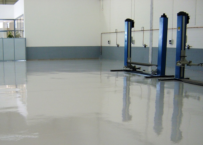 Pavimento continuo de resina en taller mecánico con elevadores de vehículos